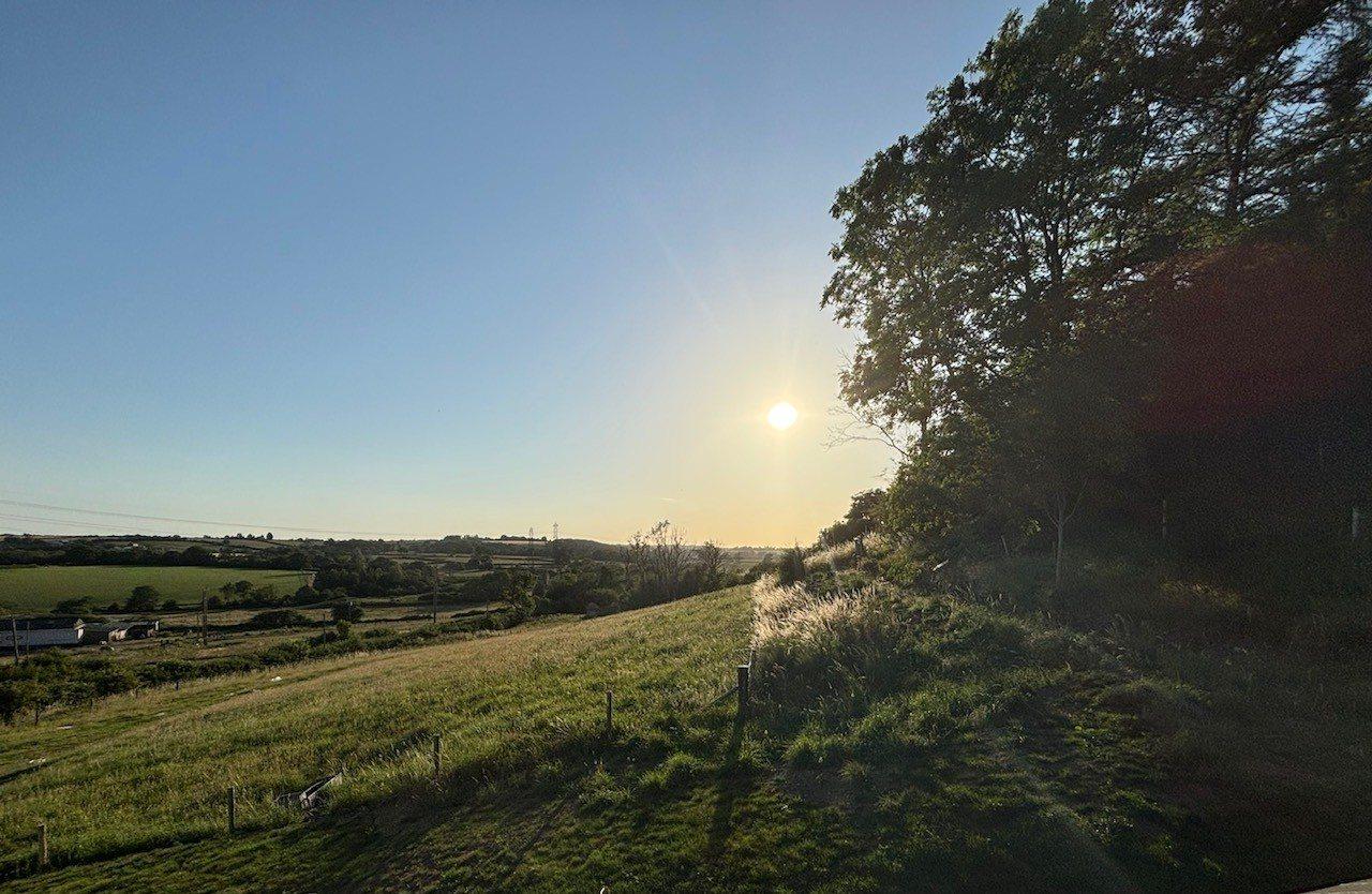 Golden hour sunlight over the fields surrounding The Barn