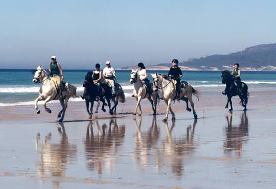 Riders on horseback along Ogmore beach